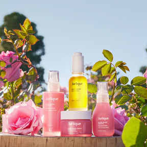Jurlique skincare products with pink roses in the background